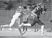  ??  ?? Legend's Connor Eise outruns Regis Jesuit's Pyreese Miller to score a touchdown during the first half Friday at EchoPark Stadium.