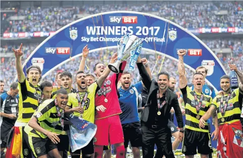  ?? REUTERS ?? Huddersfie­ld Town manager David Wagner, centre right, and his players celebrate after winning promotion to the Premier League.