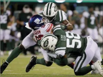  ?? JULIO CORTEZ — THE ASSOCIATED PRESS ?? Jets linebacker Avery Williamson, top, and linebacker Darron Lee (58) tackle Giants tight end Evan Engram (88) who fumbled the ball on the play during the second quarter of a preseason game.