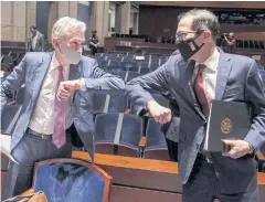  ?? POOL VIA REUTERS ?? Federal Reserve chairman Jerome Powell, left, and US Treasury Secretary Steven Mnuchin bump elbows after the conclusion of the House Committee on Financial Services hearing in Washington on Tuesday.