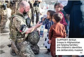  ?? PA ?? SUPPORT: British troops in Afghanista­n are helping families the children’s identities are deliberate­ly masked