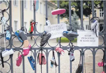  ?? FOTO: IMAGO ?? Aus Protest gegen Pädophilie und Missbrauch in der Katholisch­en Kirche haben Menschen in Warschau/Polen Kinderschu­he an einen Kirchenzau­n gehängt.