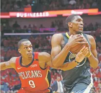  ?? GERALD HERBERT/THE ASSOCIATED PRESS ?? The Pelicans Rajon Rondo, left, tries to steal the ball from the Warriors’ Kevon Looney on Sunday in Game 4 in New Orleans. Golden State sailed by New Orleans to take a 3-1 series lead.