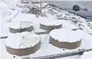  ?? COMPANY VIA AP ALYESKA PIPELINE SERVICE ?? Workers at the endpoint of the trans-Alaska oil pipeline use saws to cut up large blocks of hard-packed snow on top of the oil storage tanks at the Valdez Marine Terminal in Valdez, Alaska.