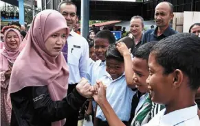  ?? — Bernama ?? Getting friendly: Fadhlina (second from left) meeting with Orang asli pupils at sk Kuala Betis in Gua Musang.