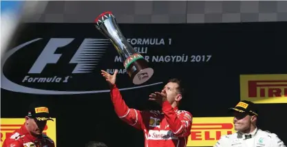  ??  ?? BUDAPEST: Winner Ferrari’s German driver Sebastian Vettel (C) is flanked by second-placed Ferrari’s Finnish driver Kimi Raikkonen (L) and thirdplace­d Mercedes’ Finnish driver Valtteri Bottas (R) as he celebrates on the podium after the Formula One...