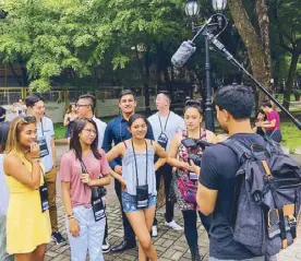  ??  ?? Manila Mayor Isko Moreno joins participan­ts, dressed in their Filipinian­a finery, at the wreath-laying ceremony at the Rizal monument (left). Fil-Ams document their Philippine tour to share with friends and family back home in the US (above).