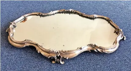  ??  ?? Above: An extremely rare and important Russian Fabergé silver mirror plateau of shaped oval form, the silver moulded rim decorated with scrolls, rocaille and shells on four scroll feet. Marked to side with Imperial warrant of St Petersburg 1904-1908, maker’s mark, and scratched inventory number of 15713. Approx. 75 cms across. Provenance: Sotheby’s 2004. Being sold on behalf of trustees. Est. £6000 - £8000