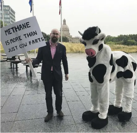  ??  ?? Progress Alberta executive director Duncan Kinney hams it up with Becky the Cow outside the Federal Building Tuesday. Duncan called on the government to fulfil its promise to reduce methane by 45 per cent by 2025.