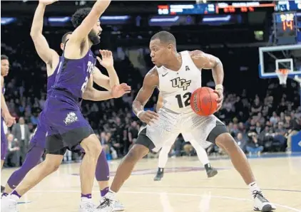  ?? KATHY WILLENS/ASSOCIATED PRESS ?? UCF G Matt Williams (12) had a team-high 15 points but he and the Knights came up short Monday night against Alex Robinson (25) and TCU.