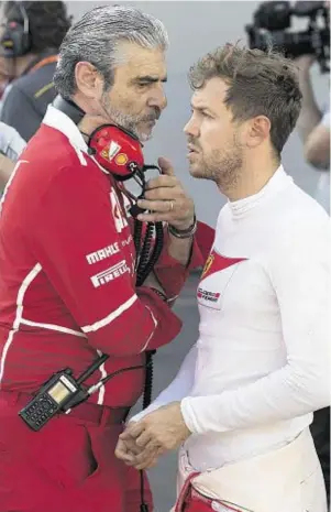  ??  ?? QUIET WORD: Ferrari chief Maurizio Arrivabene, left, talks with Ferrari driver Sebastian Vettel during a temporary halt at the Azerbaijan Grand Prix