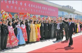  ?? AP/KYODO NEWS ?? Li Zhanshu (right), a senior Chinese official, is welcomed Saturday at Pyongyang Internatio­nal Airport in North Korea.