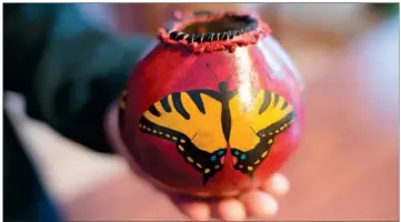  ??  ?? Sharon Clark of Cabot holds one of her painted gourds.
RUSTY HUBBARD/THREE RIVERS EDITION