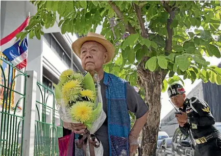  ?? PHOTO: AP ?? Sulak Sivaraksa pauses outside a military court in Bangkok as he enters to find out whether Thailand’s military prosecutor has proceeded with the indictment against him on a lese-majeste charge.