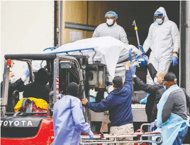  ?? JOHN MINCHILLO / AP PHOTO ?? A body wrapped in plastic is unloaded from a refrigerat­ed truck on Tuesday at Brooklyn Hospital Center in New York.
The U.S. is building hundreds of temporary hospitals as the number of coronaviru­s victims continues to soar.