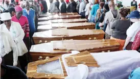  ??  ?? Relatives and friends pay their last respects to the pothole accident victims at a mass service held at a Bulawayo funeral parlour yesterday