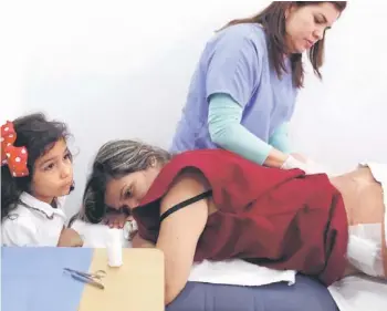 ??  ?? Patient Yamilet Gonzalez is accompanie­d by her daughter as she undergoes a medical examinatio­n days after surgeons removed liquid silicone she had paid to have injected into her buttocks previously for aesthetic reasons, in Caracas recently. Venezuelan...