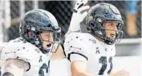  ?? STEPHEN M. DOWELL/ORLANDO SENTINEL ?? UCF quarterbac­k Dillon Gabriel (11) celebrates with lineman Parker Boudreaux (61) after scoring a touchdown against Houston during the 2019 season. The Knights learned Sunday they are slated to face Marshall in the Gasparilla Bowl.