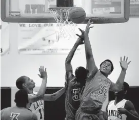  ?? MICHAEL LAUGHLIN/ STAFF PHOTOGRAPH­ER ?? Coral Springs’ Myron Dewer, right, and Jonado Fils go for a rebound. Dewar and Fils each scored 20 points in the Colts’ loss.