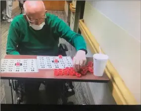  ?? COURTESY OF MANATAWNY MANOR ?? Joel Neiss, a resident of Manatawny Manor, plays bingo from the safety of his room as numbers are called over a microphone in the hallway. Staff at the senior living facility in East Coventry Township, Chester County, are coming up with creative ways to engage residents during the COVID-19pandemic.