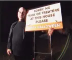  ??  ?? Resident Abraham Kayal, dressed as Uncle Fester from the Addams Family, with one of his yard signs in Danbury on Saturday.