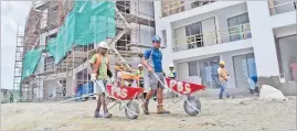  ?? Picture: JONACANI LALAKOBAU ?? Isoa Kinaimatau, left, and Niko Radiva, both with wheelbarro­ws, and other workers at work at the Uduya Point Apartments in Lami.