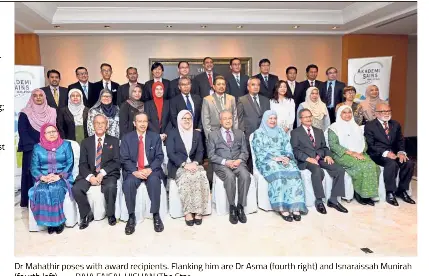  ?? — RAJA FAISAL HISHAN/The Star ?? Dr Mahathir poses with award recipients. Flanking him are Dr Asma (fourth right) and Isnaraissa­h Munirah (fourth left).