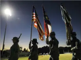  ?? DAVID GOLDMAN — THE ASSOCIATED PRESS ?? Members of a color guard walk off the field following the national anthem at a football game at South Robeson High School in Rowland, N.C., Friday, Oct. 27, 2017. The decision by the school’s cheerleade­rs to kneel during the national anthem at a recent...