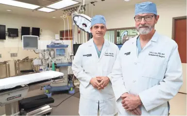  ?? MICHAEL SEARS / MILWAUKEE JOURNAL SENTINEL ?? Dr. Lyle D. Joyce and his son Dr. David L. Joyce, both cardiothor­acic surgeons, pose at Froedtert & the Medical College of Wisconsin. The father-son duo did the most recent heart transplant on Chuck Newman. Dr. Lyle Joyce also did the first transplant for Newman in 1988.