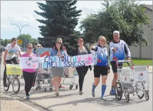  ?? NEWS PHOTO MO CRANKER ?? Push for Change founder Joe Roberts leads a group of Redcliff residents to Main Street with his shopping cart to raise awareness for youth homelessne­ss.