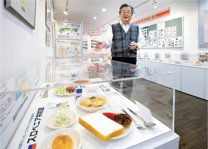  ?? Yomiuri Shimbun photos ?? School Lunch Museum Director Tsugio Osawa describes the special menu created when Japan cohosted the 2002 soccer World Cup with South Korea.