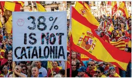  ?? JACK TAYLOR / GETTY IMAGES ?? Protesters wave Spanish flags and carry banners during a pro-unity demonstrat­ion Sunday in Barcelona, Spain. Thousands gathered in Barcelona two days after the Catalan Parliament voted to split from Spain.