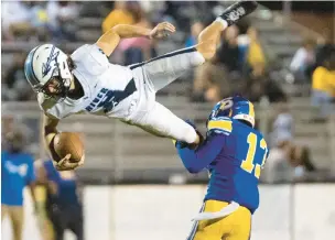  ?? MIKE CAUDILL /FREELANCE ?? Indian River quarterbac­k Tyler Allison tries to leap over Oscar Smith tackler Romaro Copeland during the second half of a game in Chesapeake. Allison and the Braves moved into playoff position by defeating Nansemond River last Friday.