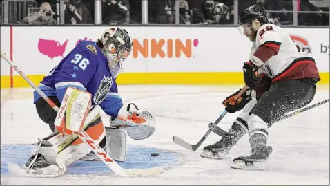  ?? Ethan Miller / Getty Images ?? Claude Giroux of Philadelph­ia scores against Anaheim goalie John Gibson during the game between the Pacific Division and the Metropolit­an Division during the All-Star Game on Saturday. Giroux added two goals in the final vs. the Central Division.