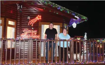 ??  ?? Brother and sister Eugene and Jenny Gannon with Christmas lights on their log cabin in Bettystown