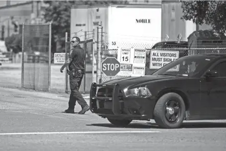  ?? VASHA HUNT/AP ?? A police officer walks at the entrance to a Mueller Co. fire hydrant plant where police said multiple people were shot to death and others were wounded Tuesday in Albertvill­e, Ala.