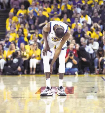  ?? Carlos Avila Gonzalez / The Chronicle ?? Kevin Durant checks his injured calf in the third quarter of Game 5 of the Western Conference semifinals against Houston. His team is undefeated in five games since his departure.