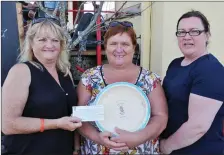  ??  ?? Eibhlín Ní Chéarna and Elaine Uí Laighin presenting Elaine Nic Eoin with her winnings after she came first in the Pláta Práta contest.