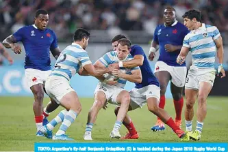  ?? —AFP ?? TOKYO: Argentina’s fly-half Benjamin Urdapillet­a (C) is tackled during the Japan 2019 Rugby World Cup Pool C match between France and Argentina at the Tokyo Stadium in Tokyo yesterday.
