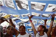  ?? Natacha Pisarenko/associated Press ?? Demonstrat­ors carry a banner with photos of people who disappeare­d during the 1976-1983 dictatorsh­ip during a march Sunday commemorat­ing the 48th anniversar­y of the coup.