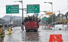  ??  ?? Al colapsar el transporte público por el agua, la gente se subió a los camiones que circulaban por la vía y que accedieron a llevarlos.