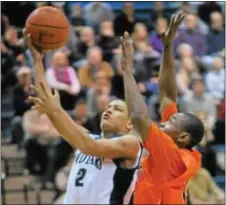  ??  ?? Josh McWilliams, left, soars to the hoop for the Indians.