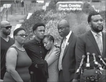  ?? The Associated Press ?? VICTIM’S FAMILY: Brandt Jean, center left, brother of shooting victim Botham Jean, hugs his sister Allisa Charles-Findley, during a news conference outside the Frank Crowley Courts Building on Monday in Dallas, about the shooting of Botham Jean by Dallas police officer Amber Guyger on Thursday. He was joined by his mother, Allison Jean, second from left, and attorney Benjamin Crump, second from right, as attorney Lee Merritt, right, speaks to the media.