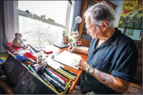  ?? (AP/The Herald-Times/Rich Janzaruk) ?? Joe Lee works on a cartoon panel Sept. 14 in his home in Bloomingto­n, Ind. The loss of two special people in Lee’s life inspired his first graphic novel, “Forgivenes­s: The story of Eva Kor, survivor of the Auschwitz twin experiment­s.”