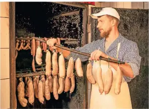  ?? FOTO: RONALD BONSS/DPA-TMN ?? Im Fleischerh­andwerk ist Nachwuchs gesucht: Azubi Maurice Münch hat sich für die Branche entschiede­n und weiß, wie Würste im Räucherofe­n für den Verzehr vorbereite­t werden.