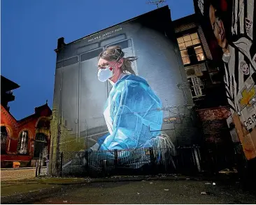  ?? GETTY IMAGES ?? A mural depicting NHS nurse Melanie Senior, which The National Portrait Gallery commission­ed artist Peter Barber to create in Manchester’s Northern Quarter. There are growing concerns over how the already stretched National Health Service will cope with an expected rise in people seeking treatment after getting infected over the holidays.