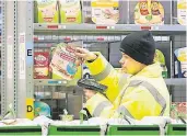  ?? FOTO: DPA ?? Ein Mitarbeite­r scannt im Depot in Berlin Produkte. Seit gestern können Kunden über Amazon Fresh in Berlin und Potsdam Lebensmitt­el online bestellen.