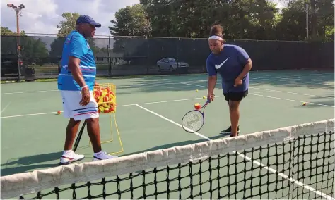  ?? (Pine Bluff Commercial/Eplunus Colvin) ?? Nadia Miller, a 12-year-old White Hall Middle School student, is coached by Kreth Simmons as she hits the tennis ball over the net.