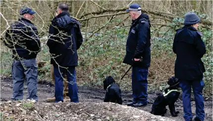  ??  ?? Search: Officers with sniffer dogs look for evidence in Hoad’s Wood near Ashford in Kent