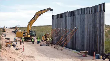  ??  ?? Trabajador­es en la edificació­n del muro fronterizo del presidente Trump